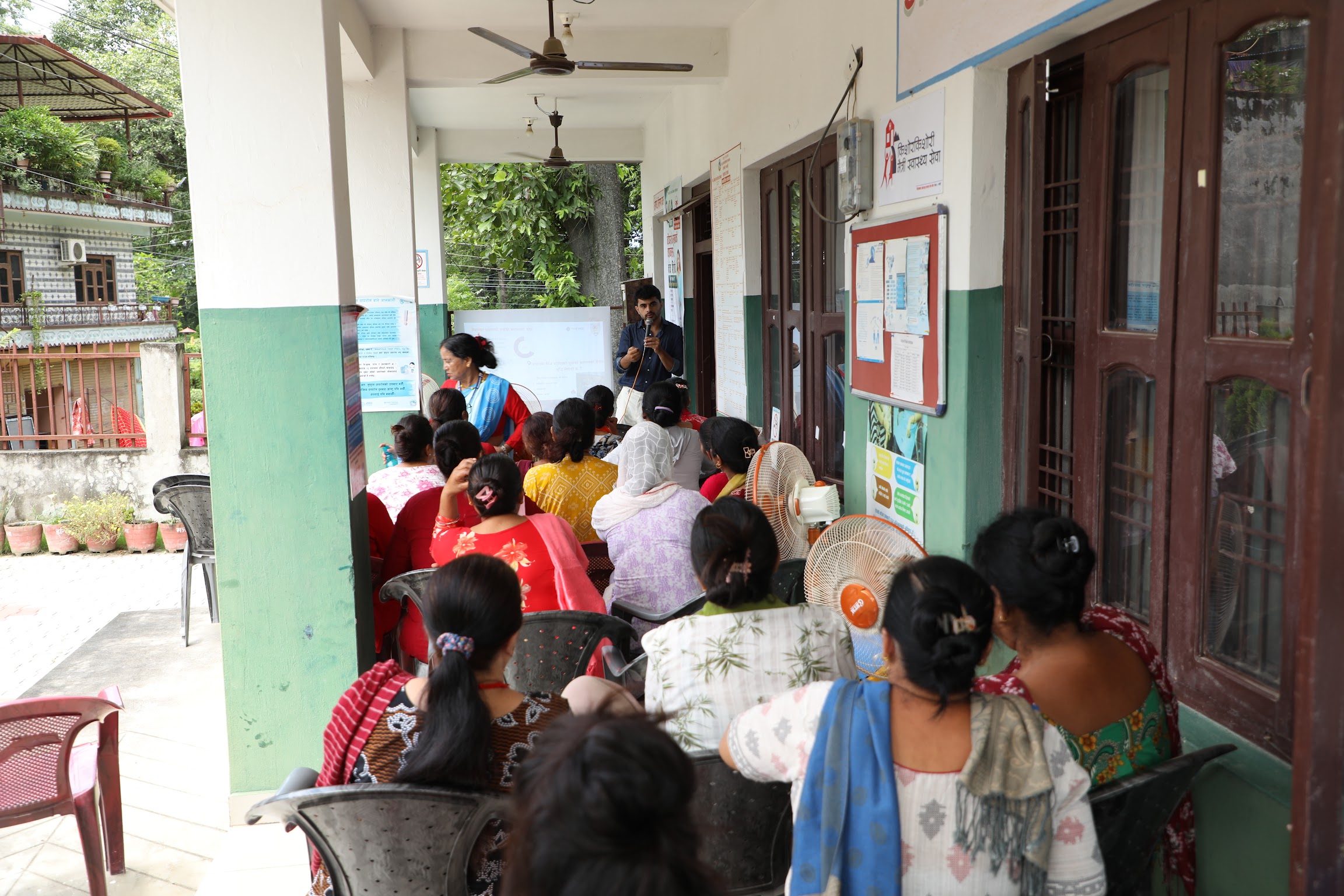 Women and local health workers take part in a community health education session.